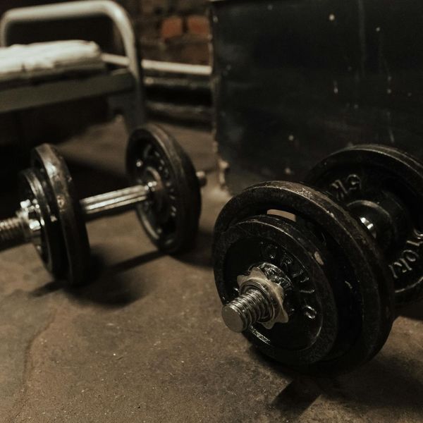 Close up of steel dumbbells on a dark gym floor